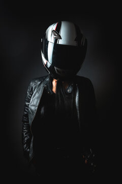 a woman stands in a helmet from a motorcycle