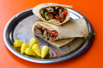 Grilled Turkish Adana, Urfa  Kebab with grilled vegetables, onion and rice on plate. Adana durum.
