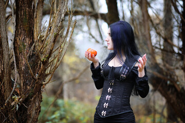 A woman in a witch suit in a forest