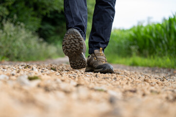 Low angle closeup view of a sole of male hiking shoes walking towards the camera - 521855984