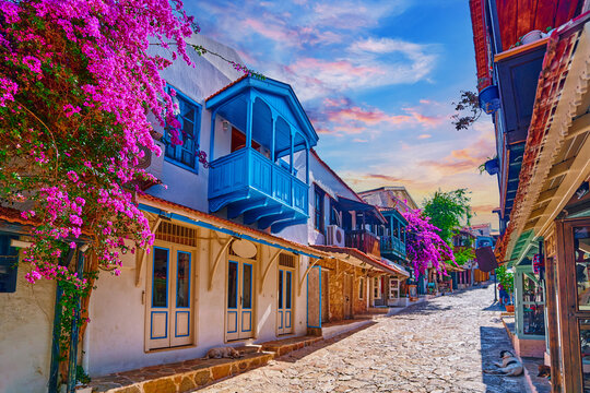 Fototapeta Old colored street view. White houses with wooden blue balconies and pink flowers in Kas city, Turkey