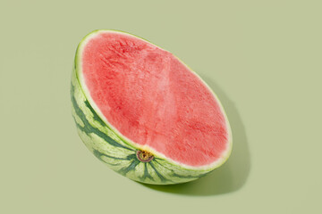 Cut watermelon on green pastel background