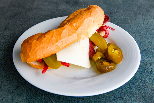 Close-up shot of Izmir's famous Turkish Traditional Kumru Sandwich, Ceşme Kumru, patso ingredients ready to eat salami, soudjouk, tomato, cheddar cheese and fried cheese. Yengen sandvic.