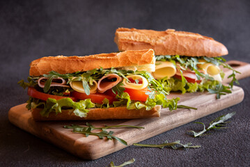 Baguette sandwich with cheese, ham, tomatoes and vegetables