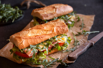 Baguette sandwich with cheese, ham, tomatoes and vegetables