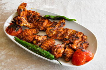 Chicken wings barbeque in a dish with BBQ sauce . Izgara tavuk sis kanat.