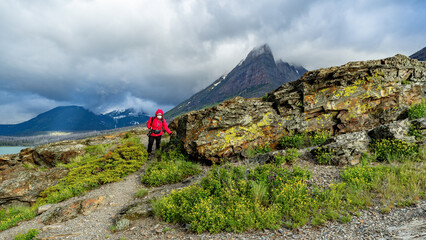 Obraz premium Tourist with camera hikes in Glacier Park
