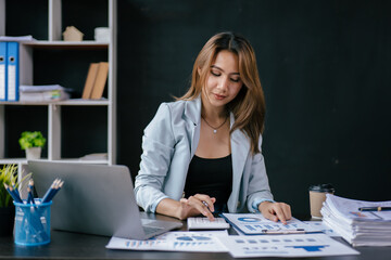 Young business women working and calculating on laptop with happy and smile face on office spec.