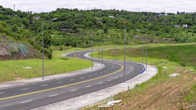 Highway Road Surrounded By Vegetation And Green Landscape During Daytime