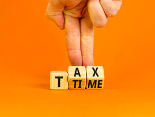 Tax time symbol. Concept words Tax time on wooden cubes. Businessman hand. Beautiful orange table orange background. Business and Tax time concept. Copy space.