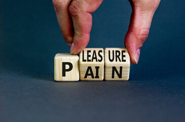 Pain or pleasure symbol. Concept words Pain or Pleasure on wooden cubes. Businessman hand. Beautiful grey table grey background. Business and pain or pleasure concept. Copy space.