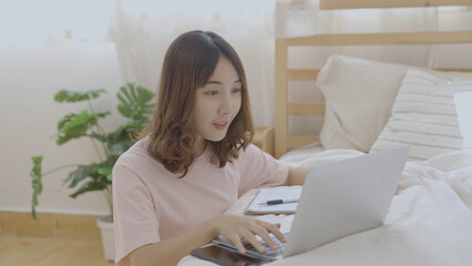 Holiday concept of 4k Resolution. Asian girls working with computers in the bedroom.