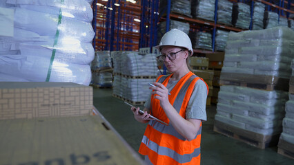 Business concept of 4k Resolution. An employee is checking the goods with a tablet in the warehouse.