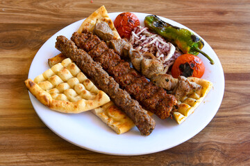Grilled Turkish Adana, Urfa  Kebab with grilled vegetables, onion and rice on plate. Adana durum .