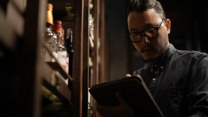 Night club concept of 4k Resolution. The bartender is checking the merchandise in the store. A group of specialized clubs that sell alcoholic beverages.