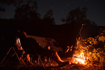 campfire in the forest in the background a campervan