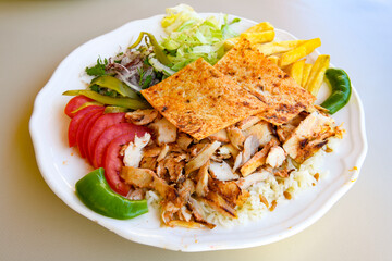 Turkish and Arabic Traditional Ramadan doner kebab with tasty tomato sauce and rice or turkish pilav in white plate on wood table background. ( Pilav ustu doner)