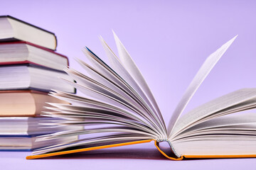 Close-up of an open book on background of a stack of books