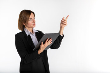 Young attractive business woman in black suit holding gadget and pointing on free space isolated on white. Copy space and place for text concept