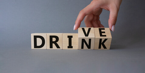 Drive vs drink symbol. Hand turns a cube and changes the word drink to drive. Beautiful grey background. Businessman hand. Business and Drive vs drink concept. Copy space