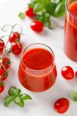 Tomato juice in a glass and fresh tomatoes