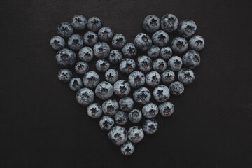 Handful of blueberries on black background. Handful of blueberries Ripe berries. Healthy Lifestyle. Useful products. Lots of vitamins.