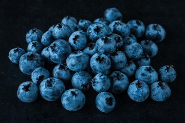Handful of blueberries on black background. Handful of blueberries Ripe berries. Healthy Lifestyle. Useful products. Lots of vitamins.