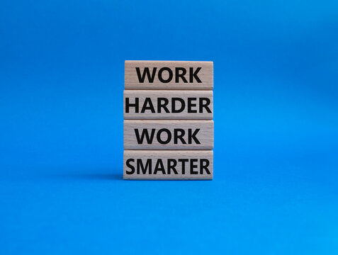 Work harder Work smarter symbol. Wooden blocks with words Work harder Work smarter. Beautiful blue background. Business concept. Copy space.