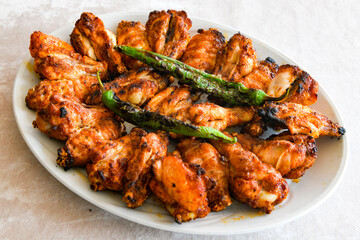 Chicken wings barbeque in a dish with BBQ sauce . Izgara tavuk sis kanat.
