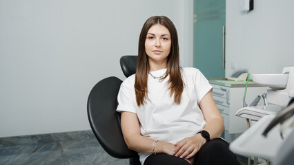 Pretty caucasian woman sitting in a chair of dental unit in dental office.