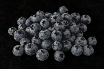 Handful of blueberries on black background. Handful of blueberries Ripe berries. Healthy Lifestyle. Useful products. Lots of vitamins.