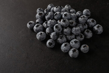 Handful of blueberries on black background. Handful of blueberries Ripe berries. Healthy Lifestyle. Useful products. Lots of vitamins.