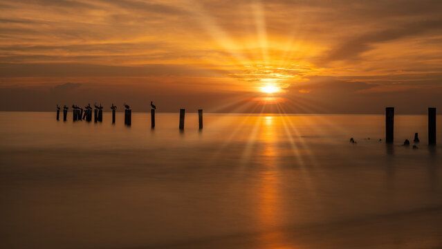 Old wooden piling/pier of historic old naples Pier in Florida at dusk. America Long exposure landscape photo at sunset.
