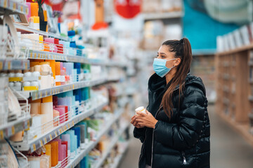 Woman with face mask buying during virus pandemic.