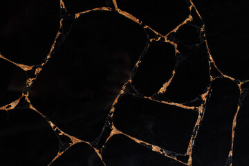 Black Obsidian semi precious stone texture with a gold leaf for exclusive interior design.