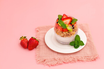 Iogurte natural com granola e frutas. Iogurte com morango, kiwi e granola. deliciosa sobremesa saudável.