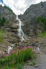 Wandernde Frau vor dem großen Wasserfall der Engstligen, rosa pinke schmalblättrige...