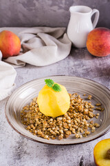 Frozen peach filled with yogurt on granola on a plate. Korean trendy Greek momo. Vertical view