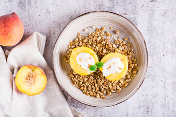 Peach halves filled with yogurt on granola on a plate. Korean trendy Greek momo. Top view