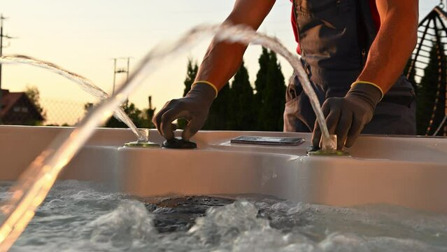 Caucasian Professional Hot Tubs Technician Finishing Garden SPA Installation in Residential Backyard Garden.