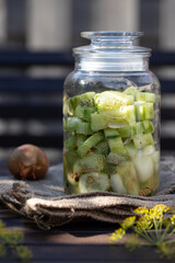 grüne frische selbstgemachte Schüttelgurken mit Dill, Senfkörner, Zwiebeln auf einem Tisch aus Holz