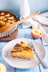 Fresh piece of peach pie and fork on a plate on the table. Homemade pastries. Vertical view