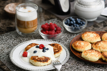 Cottage cheese pancakes with blueberries and raspberries and sour cream.