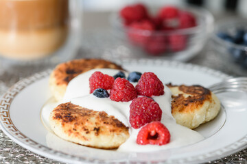 Close-up of cottage cheese pancakes with blueberries and raspberries.