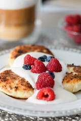 Close-up of cottage cheese pancakes with blueberries and raspberries.