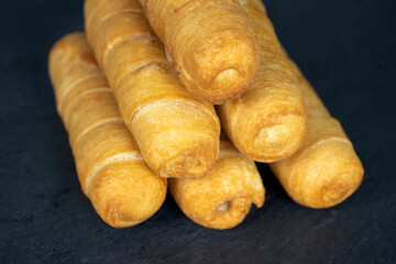 Tequenos. A piles of deep fried baked cheese sticks on dark background. Venezuelan snack