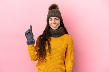 Young caucasian girl with winter hat isolated on purple background pointing up a great idea