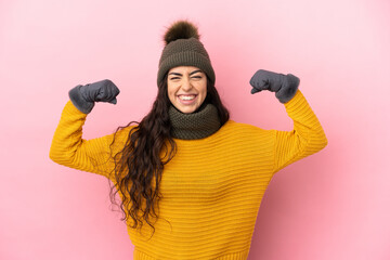 Young caucasian girl with winter hat isolated on purple background doing strong gesture