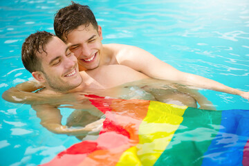 Gay couple relaxing in swimming pool with LGBT flag. Two young men enjoying nature outdoors, smiling, kissing and hugging. Young men romantic family in love. Happiness concept