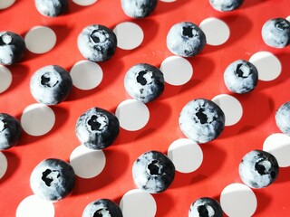 Blueberry fruits on the red pattern background